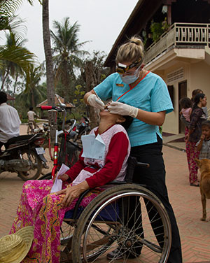 Volunteer checking a lady in a wheelchair